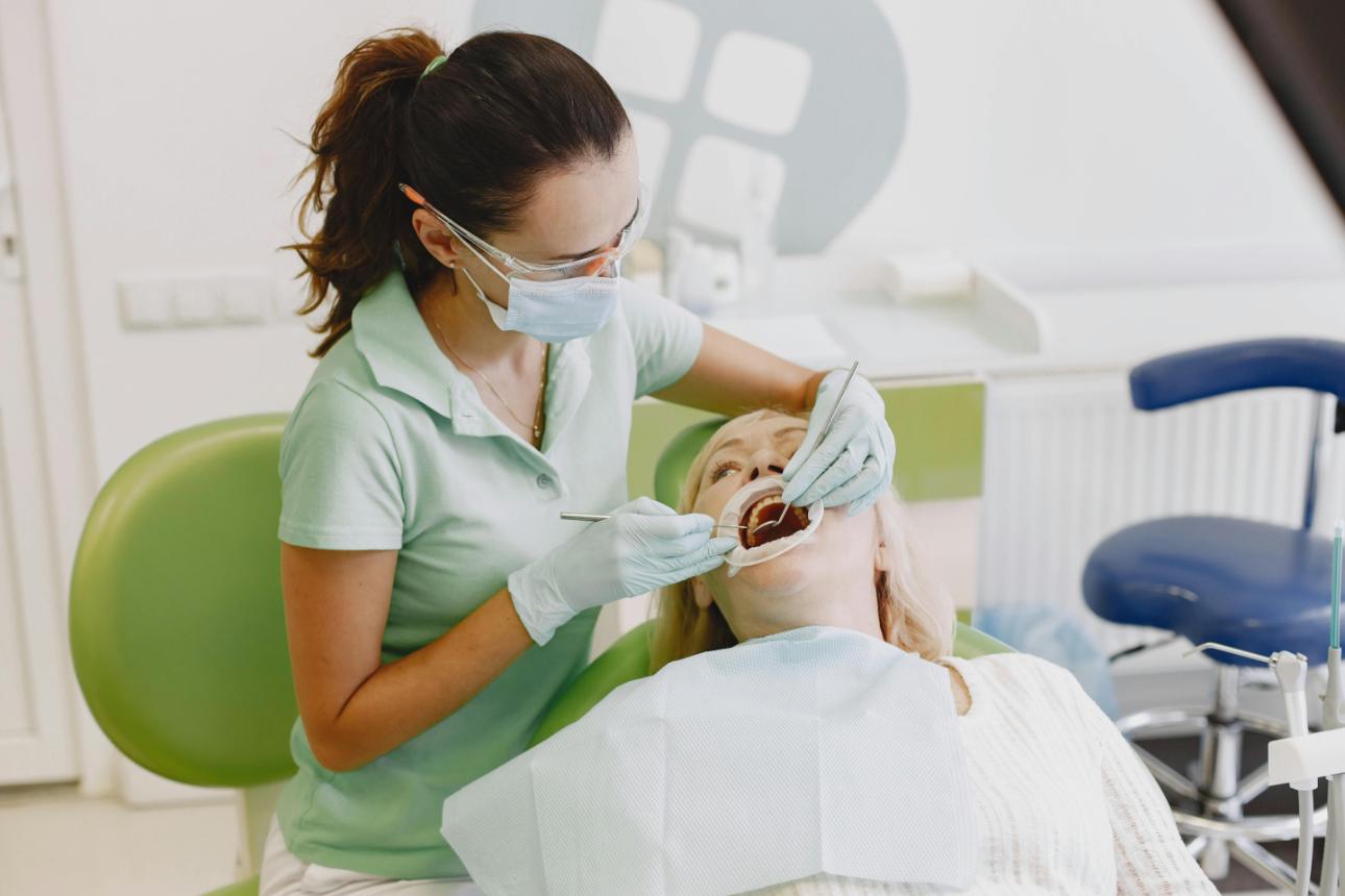 Zahnarzt untersucht Zähne einer Patientin mit Instrumenten, Zellmer Zahntechnik GmbH